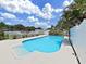 Backyard pool with crystal-clear water, surrounded by a white fence and lush landscaping at 2209 Kingswood Ln, Brandon, FL 33511