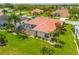 Aerial of the back of the home showcasing a screened lanai, beautiful landscaping, and a well-manicured lawn at 2221 Platinum Dr, Sun City Center, FL 33573