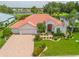 Beautiful home featuring a well-manicured lawn, a paver driveway, and a three-car garage, complemented by a lovely lake view at 2221 Platinum Dr, Sun City Center, FL 33573