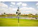 Golf course image showcasing putting green, water feature, and community homes in a desirable neighborhood under sunny skies at 2221 Platinum Dr, Sun City Center, FL 33573