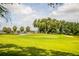 Scenic view of a golf course with lush green grass, trees, and a pond at 2221 Platinum Dr, Sun City Center, FL 33573