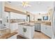 Bright, open kitchen with white cabinets, granite countertops, and stainless steel appliances at 2221 Platinum Dr, Sun City Center, FL 33573