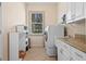 Laundry room with a washer, dryer, and granite countertop with storage at 2221 Platinum Dr, Sun City Center, FL 33573