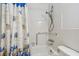 Bathroom with white tile, bathtub with shower head, and patterned shower curtain at 2310 Denmark St # 34, Clearwater, FL 33763