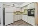 A kitchen featuring white cabinets, a refrigerator, sink, stove top, and a built-in oven at 2310 Denmark St # 34, Clearwater, FL 33763
