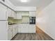 A kitchen featuring white cabinets, a refrigerator, sink, stove top, and a built-in oven at 2310 Denmark St # 34, Clearwater, FL 33763