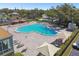 Community swimming pool surrounded by lounge chairs and mature trees at 2310 Denmark St # 34, Clearwater, FL 33763