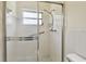 Bathroom shower with glass doors, white tile, and a shower head with controls at 2311 Brisbane St # 45, Clearwater, FL 33763