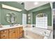 Bathroom has a jacuzzi tub, glass block window and green walls at 2454 Shadecrest Rd, Land O Lakes, FL 34639