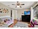 Bedroom with a television, window with curtains and wood floor at 2454 Shadecrest Rd, Land O Lakes, FL 34639
