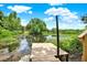 A wooden dock extending into a calm body of water with lush greenery and a clear sky at 2454 Shadecrest Rd, Land O Lakes, FL 34639