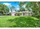 Charming single-story home featuring a lush green lawn, beautiful landscaping, and a two-car garage at 2454 Shadecrest Rd, Land O Lakes, FL 34639