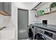 Laundry room features stainless steel washer and dryer with convenient built-in shelving at 2454 Shadecrest Rd, Land O Lakes, FL 34639