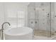 Elegant bathroom features a free standing tub, seamless shower, and window shutters at 2819 Safe Harbor Dr, Tampa, FL 33618