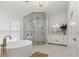 Well-lit bathroom with marble floors boasts a soaking tub and seamless glass shower at 2819 Safe Harbor Dr, Tampa, FL 33618
