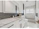 Bathroom featuring black and white vanity with marble countertop, modern fixtures, and tiled backsplash and floors at 2819 Safe Harbor Dr, Tampa, FL 33618