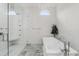 Elegant bathroom with a freestanding tub, glass shower, and stylish tiled walls at 2819 Safe Harbor Dr, Tampa, FL 33618