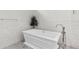A luxurious white bathtub with modern chrome fixtures sits against a stylish tile wall at 2819 Safe Harbor Dr, Tampa, FL 33618