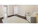 Bedroom featuring wood floors, neutral furniture and plush rug, leading to bathroom at 2819 Safe Harbor Dr, Tampa, FL 33618