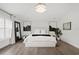 Bright bedroom with wood floors features a tufted headboard, chandelier and plantation shutters at 2819 Safe Harbor Dr, Tampa, FL 33618