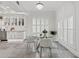 Dining area with modern glass table and chairs, complemented by kitchen's bright white cabinetry at 2819 Safe Harbor Dr, Tampa, FL 33618