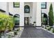 Elegant home entrance with a brick pathway, arched windows, and manicured landscaping at 2819 Safe Harbor Dr, Tampa, FL 33618