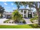 Striking two-story home with lush landscaping, brick driveway, and modern architectural details at 2819 Safe Harbor Dr, Tampa, FL 33618