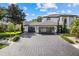 Spacious three-car garage featuring modern glass doors and a paved driveway, surrounded by lush greenery at 2819 Safe Harbor Dr, Tampa, FL 33618