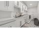 Well-organized laundry room featuring white cabinetry, modern appliances, and patterned tile flooring at 2819 Safe Harbor Dr, Tampa, FL 33618
