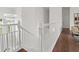 A white staircase leads to a hallway with hardwood floors and a modern chandelier at 2819 Safe Harbor Dr, Tampa, FL 33618