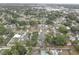 An aerial view shows a quiet residential neighborhood with tree-lined streets, well-kept homes, and a community pool at 3212 34Th N Ave, St Petersburg, FL 33713