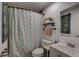 Cozy bathroom featuring a shower with floral shower curtain, white toilet, and sink with a charming mirror at 3212 34Th N Ave, St Petersburg, FL 33713