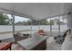 The screened porch includes comfortable seating and a table, perfect for relaxation and outdoor enjoyment, with views of a fenced yard at 3212 34Th N Ave, St Petersburg, FL 33713