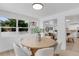 Sunlit dining room with modern round table and view of living area and updated kitchen at 3381 19Th Sw Pl, Largo, FL 33774