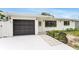 Charming single-story home with a black garage door and well-manicured landscaping at 3381 19Th Sw Pl, Largo, FL 33774