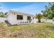 Side view of clean white home with black frame windows, garden bed, and an enclosed backyard at 3381 19Th Sw Pl, Largo, FL 33774