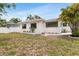 Charming white home with new black frame windows, manicured landscaping, and bright exterior lighting at 3381 19Th Sw Pl, Largo, FL 33774