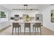 Modern kitchen with island, barstool seating, stainless appliances, and pendant lighting at 3381 19Th Sw Pl, Largo, FL 33774