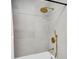 Closeup of a modern shower with gold fixtures and grey tile at 3381 19Th Sw Pl, Largo, FL 33774