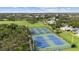 Aerial view of a park featuring tennis and pickleball courts surrounded by lush greenery and residential houses at 3415 Overlook Ne Dr, St Petersburg, FL 33703