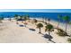 Aerial shot of a sandy beach, a gazebo, and palm trees extending to the blue ocean at 401 Windrush Bay Dr, Tarpon Springs, FL 34689