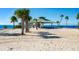 Picturesque beach view with a gazebo, palm trees, and the ocean in the background at 401 Windrush Bay Dr, Tarpon Springs, FL 34689