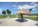 Outdoor patio with beach views, seating, and tiki umbrella at 401 Windrush Bay Dr, Tarpon Springs, FL 34689