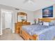 Cozy bedroom featuring a wooden dresser, nightstand and a ceiling fan for added comfort at 401 Windrush Bay Dr, Tarpon Springs, FL 34689