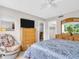 Well-lit bedroom with a dresser, TV, ceiling fan and a comfy chair adding to the room's appeal at 401 Windrush Bay Dr, Tarpon Springs, FL 34689