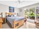 Bright bedroom with a large window, ceiling fan, and a cozy bed with decorative pillows at 401 Windrush Bay Dr, Tarpon Springs, FL 34689