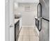 Compact kitchen featuring stainless steel appliances and neutral tile flooring at 401 Windrush Bay Dr, Tarpon Springs, FL 34689