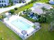 Aerial view of the community pool, featuring lounging chairs, palm trees, and manicured landscaping at 401 Windrush Bay Dr, Tarpon Springs, FL 34689