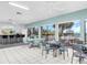 Well-lit recreation room with tile floors, bar, tables, chairs, and views of the pool area at 401 Windrush Bay Dr, Tarpon Springs, FL 34689