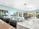 Well-lit recreation room with tile floors, bar, tables, chairs, and views of the pool area at 401 Windrush Bay Dr, Tarpon Springs, FL 34689